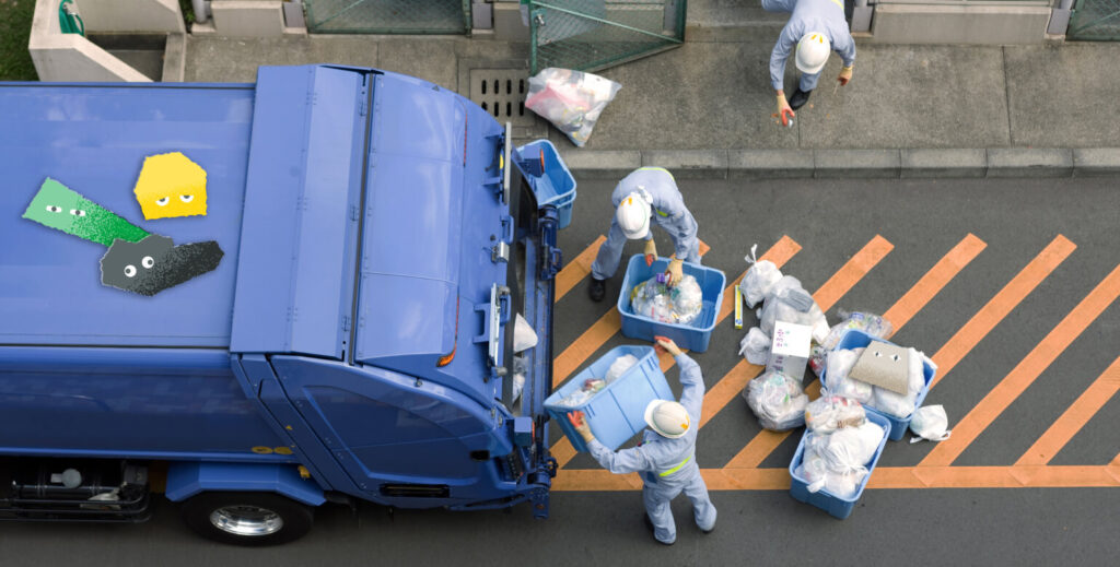 作業員がゴミ収集車へ一般廃棄物を積み込む様子。