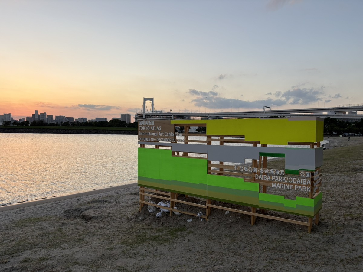 夕暮れのお台場海浜公園に立つTOKYO ATLASのサイン看板